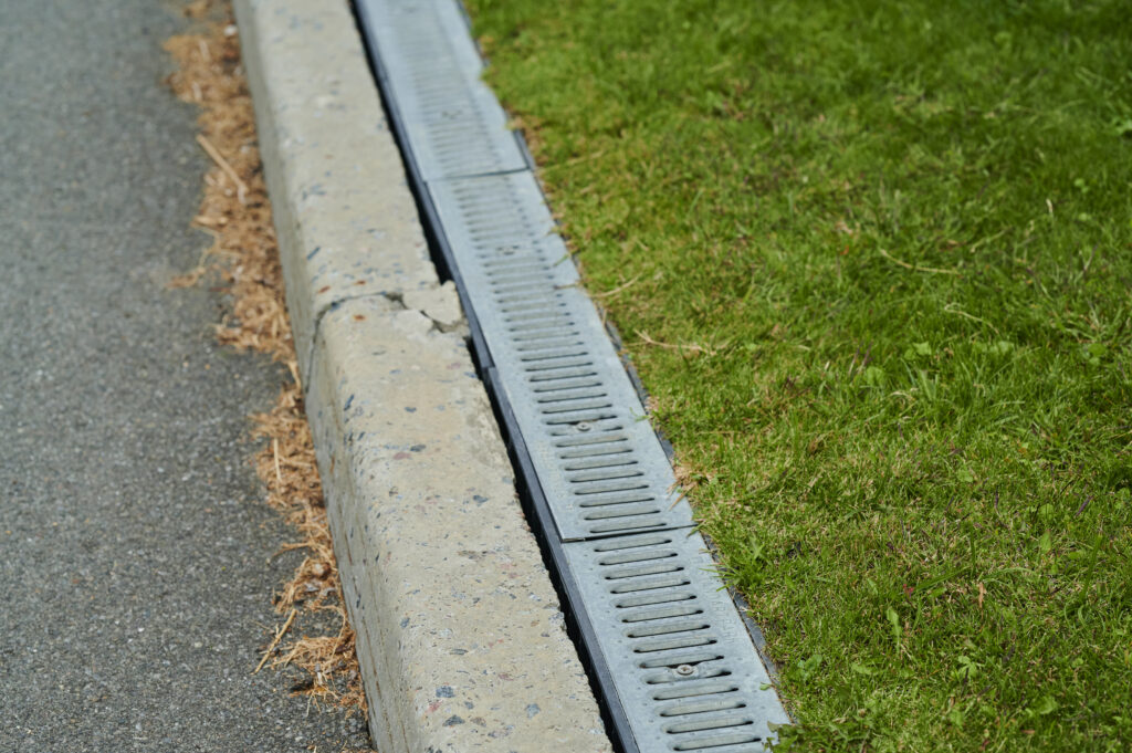 Concrete rain drain on the street in landscape design, drainage of rain underground sewerage system